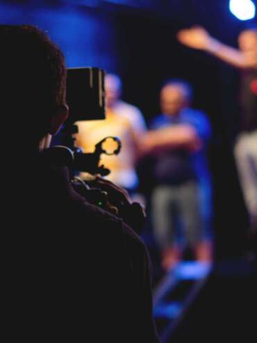 man-standing-on-stage-holding-microphone-1870438